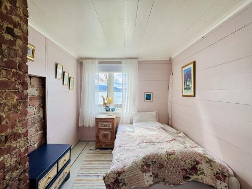 Rose rommet med original teglvegg og utsikt mot Hardangerfjorden på Kramsjø Gjestgiveri Anno 1860.